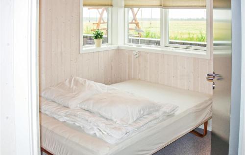 Bett in einem Zimmer mit zwei Fenstern in der Unterkunft 4 Bedroom Awesome Home In Karby in Karby