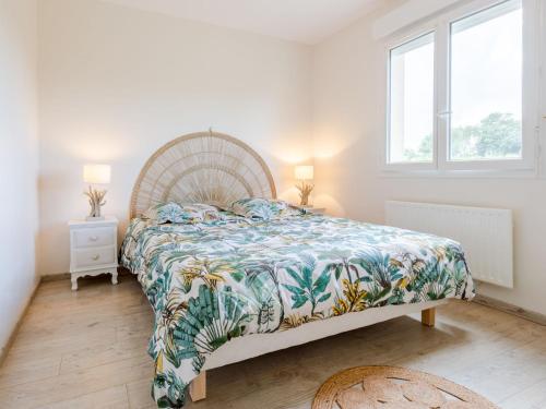 - une chambre avec un grand lit et un couvre-lit coloré dans l'établissement Holiday Home D day by Interhome, à Hiesville