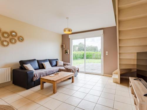 un salon avec un canapé et une table dans l'établissement Holiday Home D day by Interhome, à Hiesville