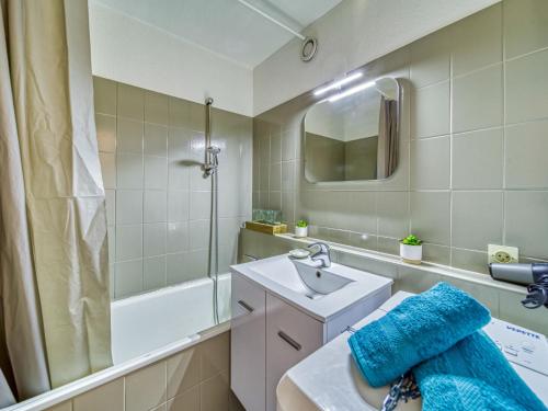 une salle de bain avec un lavabo, un miroir et une baignoire dans l'établissement Apartment Vostok Zodiaque-92 by Interhome, au Corbier