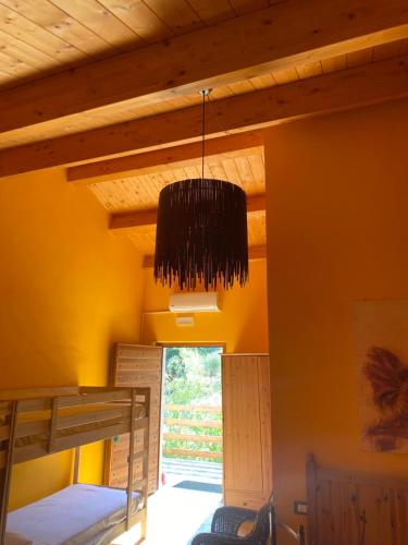 a room with a bed and a ceiling with a chandelier at Lo Scoiattolo Country House in Montorio al Vomano