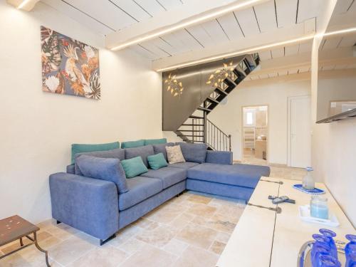 a living room with a blue couch and a staircase at Holiday Home Malanuit by Interhome in Bauduen