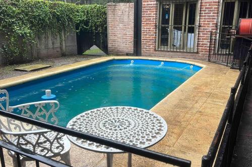a swimming pool with a table and a table and a chair at Monica’s Apartments in Canning