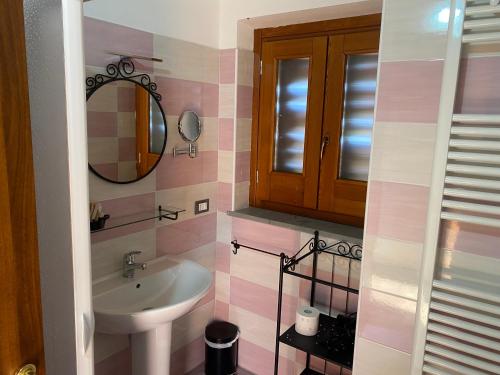 W łazience znajduje się umywalka i lustro. w obiekcie Lo Scoiattolo Country House w mieście Montorio al Vomano