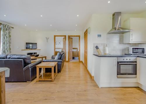 a kitchen and living room with a couch and a table at Heart Of Wales Lodges in Penybont