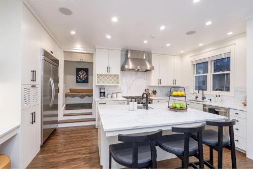 una cocina con armarios blancos y una gran isla con taburetes. en 425 Depot Ave home, en Telluride
