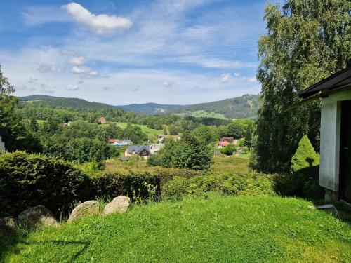 a view of a field of grass with a house at Holiday Home Na Stráži by Interhome in Smržovka