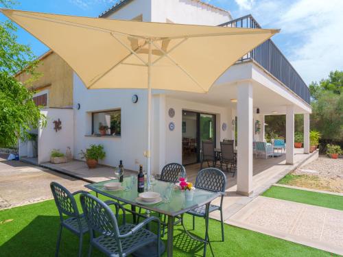 un patio con tavolo, sedie e grande ombrellone giallo di Holiday Home Son Baulo by Interhome a Can Picafort
