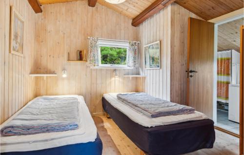 2 Betten in einem Zimmer mit Holzwänden in der Unterkunft Gorgeous Home In Fan With Kitchen in Fanø