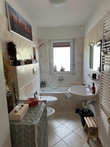 a bathroom with a sink and a tub and a toilet at COSTALUNGAHOUSE TrekkingBikeSki selfcheck-in apartment in Carezza al Lago