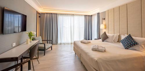 a hotel room with two beds and a desk at Ceccarini 9 home suite home in Riccione