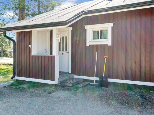 una pequeña casa roja con una puerta y un trapeador en Holiday Home Hirvasaho a1 by Interhome, en Saariselkä