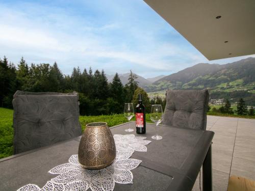 a table with a bottle of wine and two glasses at Apartment Mäuerl by Interhome in Hart im Zillertal