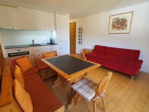 uma sala de estar com um sofá vermelho e uma mesa em Apartment Casa Fadail Seura 11 by Interhome em Lenzerheide