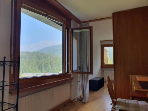 um quarto com uma grande janela com vista para uma montanha em Apartment Casa Fadail Seura 11 by Interhome em Lenzerheide