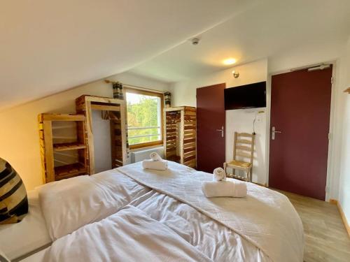 une chambre avec un grand lit avec deux serviettes dessus dans l'établissement Le Petit Loup, appartement neuf avec jardin, à Gerbépal