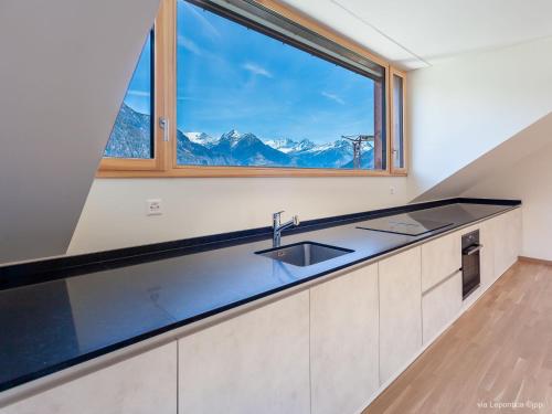 uma cozinha com um lavatório e uma grande janela em Apartment Casa Lepontica-2 by Interhome em Leontica