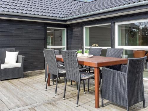 een terras met een houten tafel en stoelen bij Holiday Home Christl - 1km from the sea in Western Jutland by Interhome in Vejers Strand