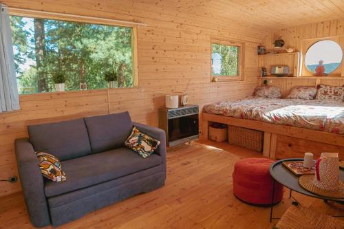 1 dormitorio con sofá y 1 cama en una cabaña en Meadowland - Samota Stříbrník, 