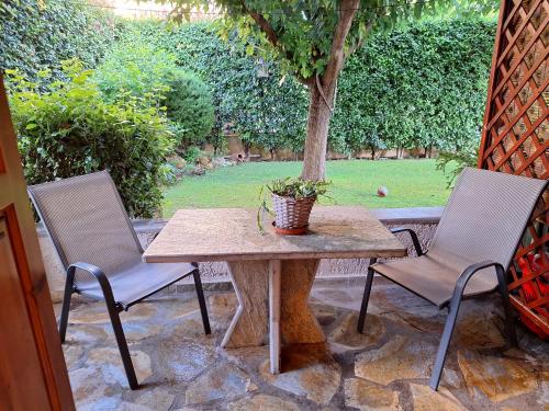 a table and two chairs on a patio with a tree at Skourgias Rooms in Kala Nera