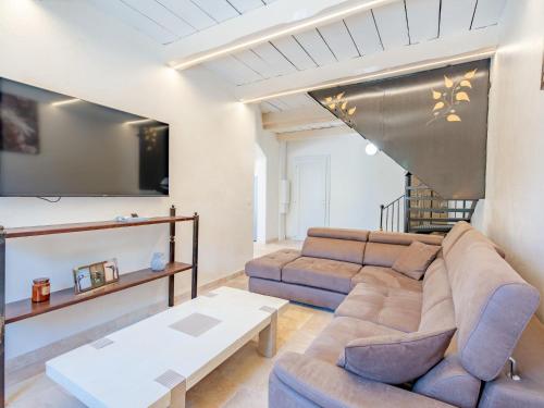 a living room with a couch and a tv at Holiday Home Marges by Interhome in Bauduen