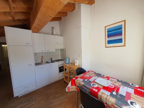 a kitchen with white cabinets and a table in a room at Apartment Casa Fadail Seura 21 by Interhome in Lenzerheide