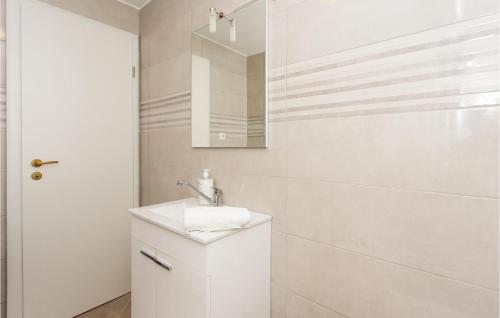 Baño blanco con lavabo y espejo en Awesome Home In Bajagic With Jacuzzi, en Bajagić