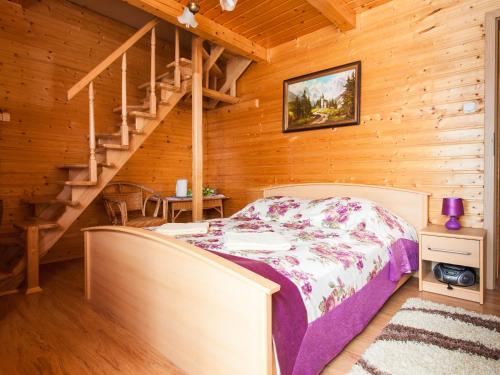 a bedroom in a log cabin with a bed and stairs at Holiday Home Antoś by Interhome in Baligród