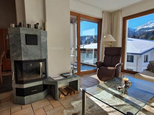 uma sala de estar com lareira e uma cadeira em Apartment Ferienwohnung Kinsella by Interhome em Lenzerheide