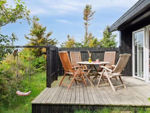 een houten terras met een tafel en stoelen erop bij Holiday Home Isabel - 500m from the sea in NW Jutland by Interhome in Torsted
