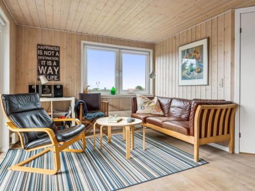 een woonkamer met een bank en een tafel en stoelen bij Holiday Home Isabel - 500m from the sea in NW Jutland by Interhome in Torsted