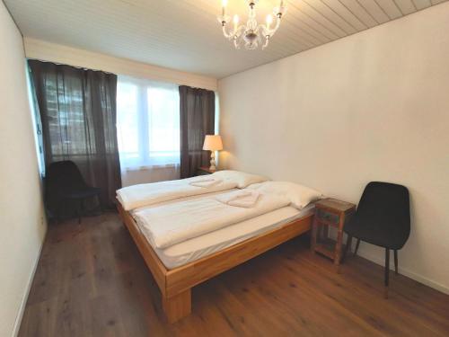 1 dormitorio con cama y lámpara de araña en Apartment Verbena by Interhome, en Davos