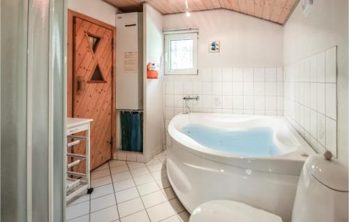 Sønder YdbyにあるAmazing Home In Hurup Thy With House A Panoramic Viewの白いバスルーム(バスタブ付)、窓が備わります。