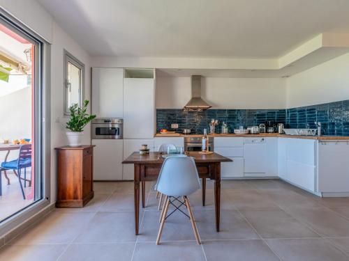 une cuisine avec des armoires blanches et une table en bois dans l'établissement Apartment Les Grenadines-6 by Interhome, à La Grande Motte