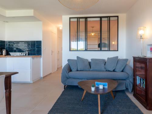 un salon avec un canapé bleu et une table dans l'établissement Apartment Les Grenadines-6 by Interhome, à La Grande Motte