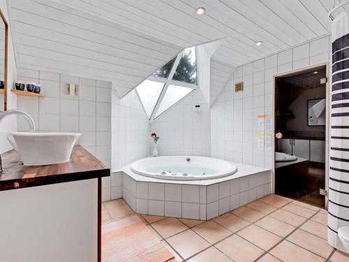 baño grande con bañera y lavamanos en Holiday Home Hunno - 3km from the sea in Western Jutland by Interhome, en Nørre Nebel