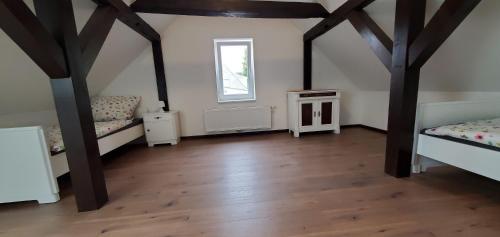 Zimmer im Dachgeschoss mit 2 Betten und einem Fenster in der Unterkunft Haus Oderbruch in Neulewin