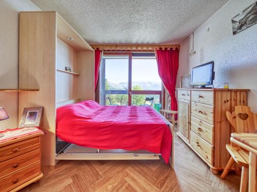 - une chambre avec un lit rouge et une fenêtre dans l'établissement Studio Lunik Orion-49 by Interhome, au Corbier