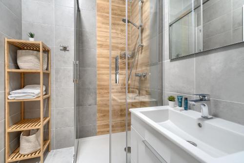 uma casa de banho com um lavatório branco e um chuveiro em Lovely SPA 31 em Dziwnów