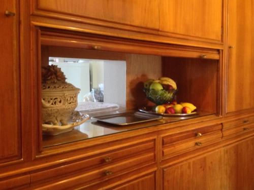 a mirror in a wooden cabinet with a bowl of fruit at B&B Bruxelles Margherita in Genoa