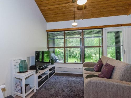 een woonkamer met een bank en een tv bij Holiday Home Säästöloma 5 f 22 by Interhome in Nurmes