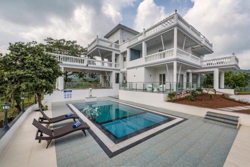 an exterior view of a house with a swimming pool at SaffronStays Ivory Mansion in Pen