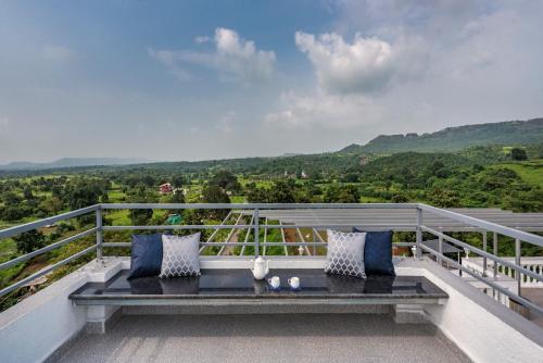 a bench on the balcony of a house at SaffronStays Ivory Mansion in Pen
