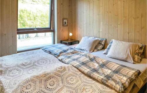um quarto com uma cama grande e uma janela em Awesome Home In Straumgjerde With Kitchen 
