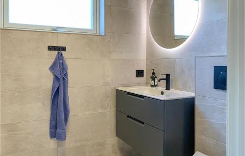 uma casa de banho com um lavatório e um espelho em Awesome Home In Straumgjerde With Kitchen 