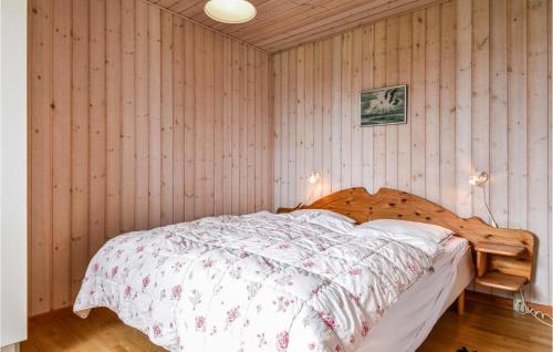 een slaapkamer met een bed met een houten muur bij Nice Home In Lemvig With Wifi in Lemvig