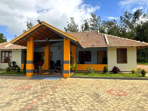 a small house with a yellow and white at STAYMAKER Siri Vismaya Home Stay in Chikmagalūr