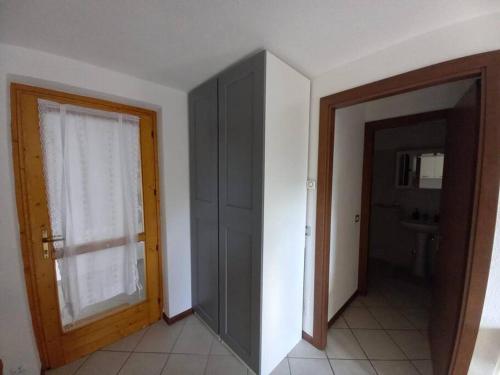 um quarto vazio com uma porta e uma janela em CASA TATA -Appartamento vista mozzafiato em Lizzola Alta