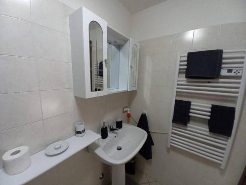 a white bathroom with a sink and a mirror at CASA TATA -Appartamento vista mozzafiato in Lizzola Alta