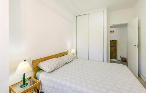 Beautiful Apartment In Granada With Kitchen في غرناطة: غرفة نوم بيضاء فيها سرير ومصباح